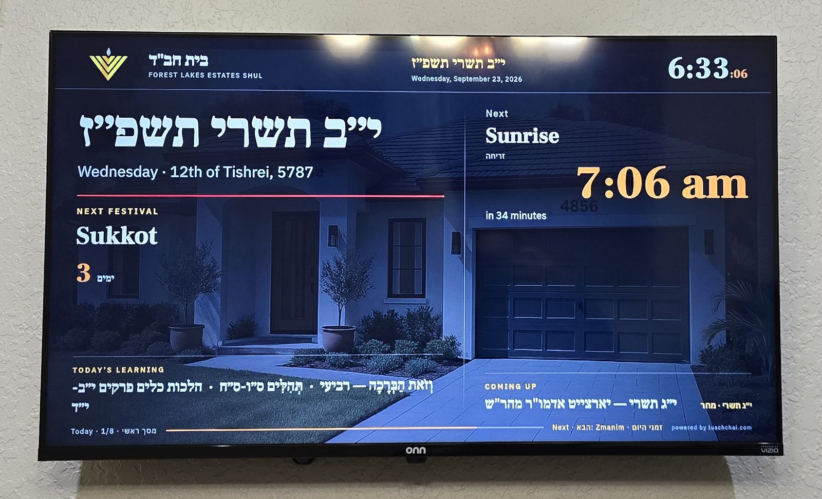 The Luach Chai board on the wall of the Forest Lakes Estates shul, set to English, showing 12 Tishrei, sunrise in 34 minutes, Sukkot in 3 days and the day's learning -- running with the internet switched off.